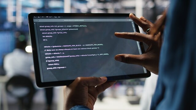 Close up of data center software developer checking code on tablet used to update equipment. Server hub expert using programming language script on device to do maintenance, camera A