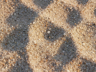 An abstract image of sand with natural patterns and small dew drops, creating a peaceful and textured scene. The soft lighting highlights the intricate design of the sand, emphasizing nature's beauty.