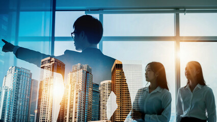 朝日夕日の中の都市オフィスで進路を指し示すビジネスパートナーリーダーと従う従業員の選択した進む未来