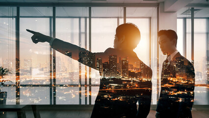 朝日夕日の中の都市オフィスで進路を指し示すビジネスパートナーリーダーと従う従業員の選択した進む未来