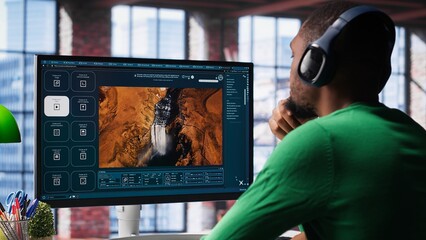 Computer screen displays digital visuals generated through AI. Young person uses software combining data and machine learning, text prompts to design graphics at home office. Camera A.