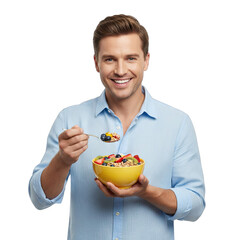 A Caucasian Man Smiling Holding A Yellow Bowl Of Cereal With Fruit And A Spoonful Of Cereal In The Other Hand Against A Black Background With A Blue Shirt