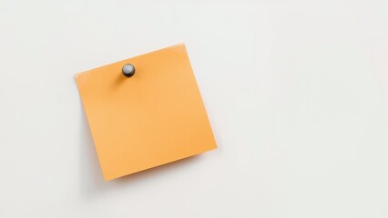 A blank orange sticky note attached to a white surface with a pushpin.