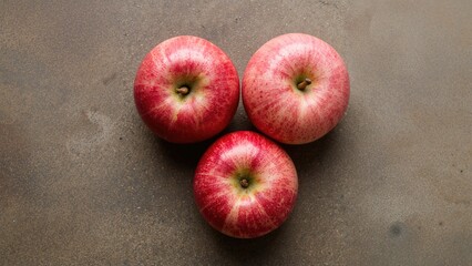 Three apples arranged on a surface.