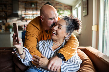Mature couple laughing during video call at home