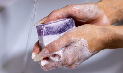 Fototapeta premium Woman is packing handmade natural soap as a gift for New Year and Christmas.
