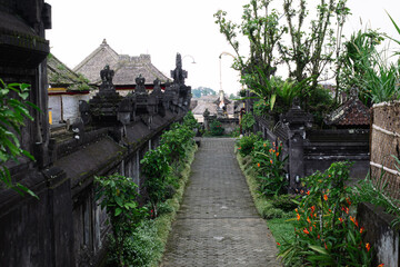 Traditional Balinese pathway with stone walls and tropical garden