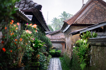 Rain falling on traditional village pathway between buildings