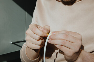 A young man glues a rubber profile to a door frame.