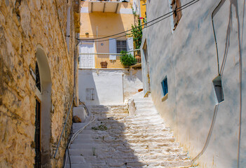 Old white stone staircase between house walls, Symi island, Greece
