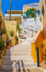 Stone white stairs between yellow Symi houses, Symi island, Greece