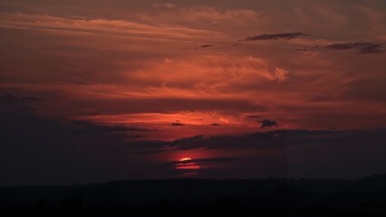 Obraz premium Sunset with a fiery sky and clouds, creating a dramatic evening scene with warm hues.