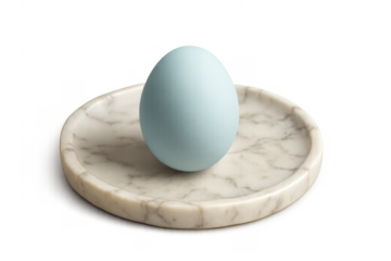 Light blue egg resting on marble plate