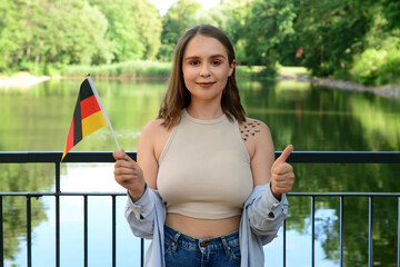 Young woman with flags of Germany in park