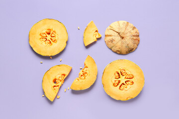 Pieces of sweet melon and seeds on lilac background