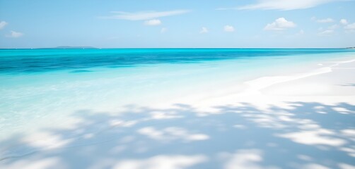 Beautiful beach views with clear blue water and soft white sand, bright sunshine and calm waves.