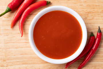 Sriracha sauce in a bowl on wooden background, Chili sauce, Table top view