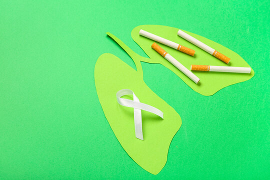 Paper lungs with cigarettes and white ribbon on green background. Lung cancer concept - Powered by Adobe