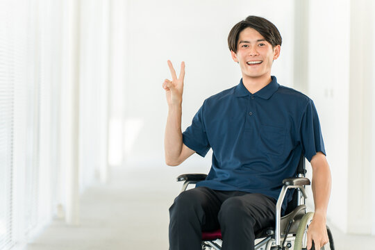 Young Asian man in a wheelchair (handicap, barrier-free, charity, care, welfare)