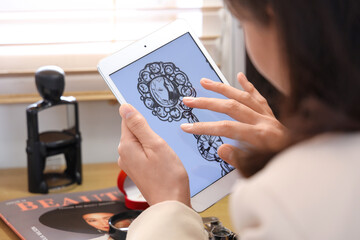 Female jewelry designer working with laptop in office
