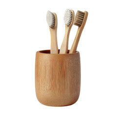 Four bamboo toothbrushes standing in a wooden holder on a white background