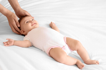 Obraz premium Cute little baby getting head massage on bed