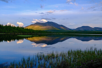 Sunset panorama of small lake with mountain reflection in Siberia, Buryatia, Russia
