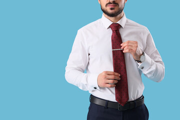 Young businessman with tie on blue background