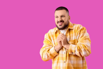 Apologetic young man on violet background