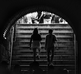 Urban street photography silhouettes walking up subway stairs from darkness to light black and white city life candid moments crowd above underground passage everyday commute seeking daylight freedom