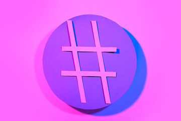 Hashtag made of paper on pink background