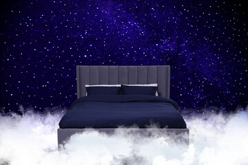 Fototapeta premium Large bed on fluffy clouds in starry night sky