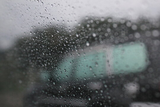 Raindrops on Glass Surface with Blurred Background - Powered by Adobe