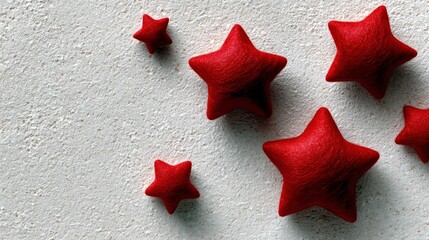 Close-up of red star shapes scattered on a textured white surface. Decorative and festive.