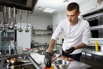 Chef cooking in the modern kitchen in hotel restaurant, preparing shrimp salad