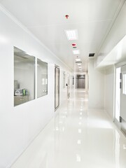 Bright, clean hallway with white walls and shiny floor.