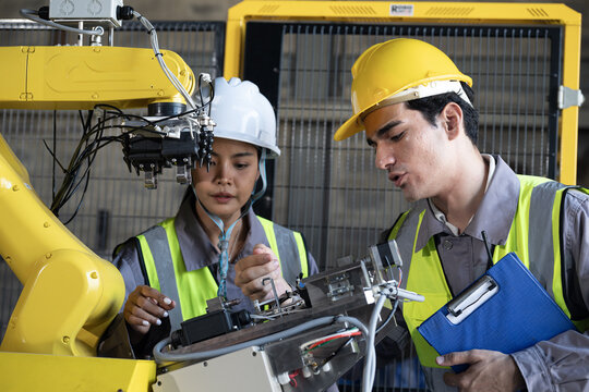 Industrial robot maintenance engineers focus safety and precision factory floor, collaborative teamwork ensures efficient inspection and repair bright light within modern industrial setting