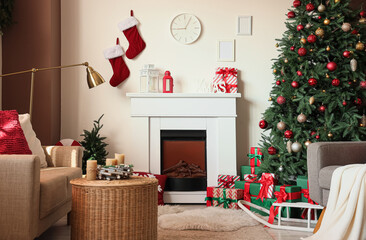 Interior of festive living room with Christmas tree, grey sofa, fireplace and clock