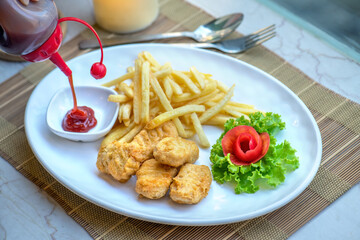 A plate of chicken nuggets, french fries, and ketchup.