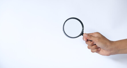 Close-up holding a magnifying glass on a white background.