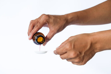 healthcare, people and medicine concept - woman pouring medication or antipyretic syrup from bottle to spoon