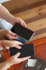Women hands holding smartphones sharing digital content