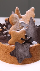 Delicious chocolate tart decorated with star and leaf cookies, walnuts, and cape gooseberries on a marble background. Perfect for holiday dessert, bakery presentation, or festive food photography