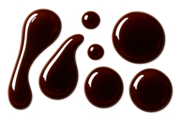 Melting chocolate sauce drops and streaks creating sweet dessert elements on transparent background