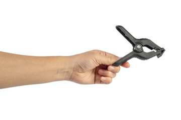 A studio shot of a black plastic spring clamp in hand isolated on a transparent background