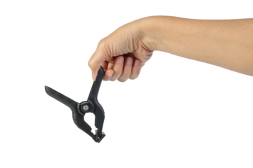 A studio shot of a black plastic spring clamp in hand isolated on a transparent background