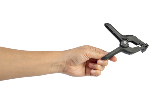 A studio shot of a black plastic spring clamp in hand isolated on a transparent background