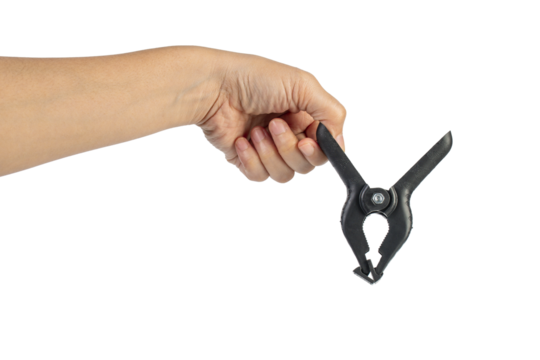 A studio shot of a black plastic spring clamp in hand isolated on a transparent background