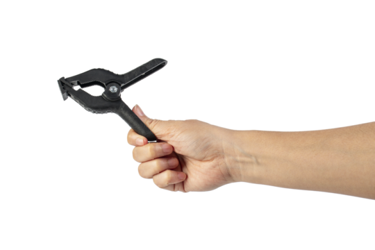 A studio shot of a black plastic spring clamp in hand isolated on a transparent background