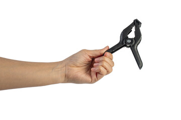 A studio shot of a black plastic spring clamp in hand isolated on a transparent background